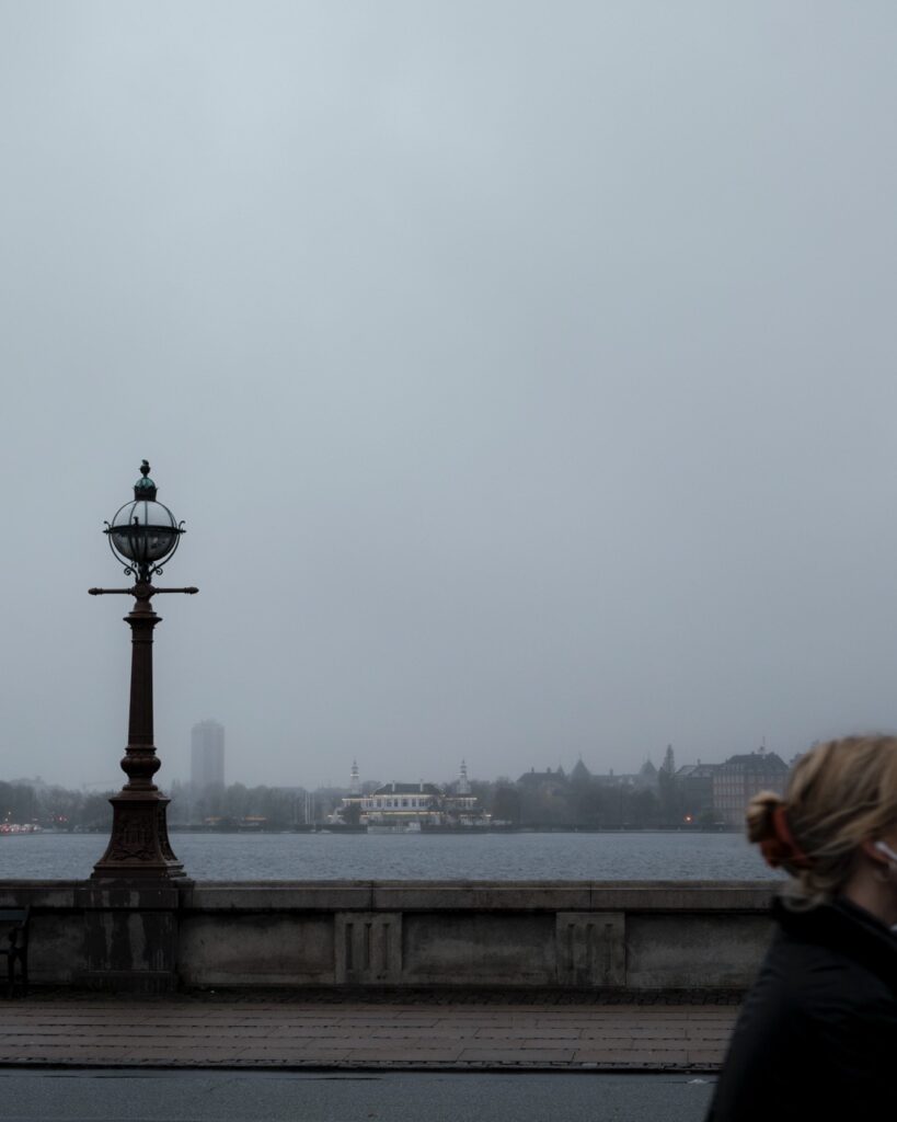 A cyclist biking in rainy weather along Dronning Louses Bro in Copenhagen, Denmark