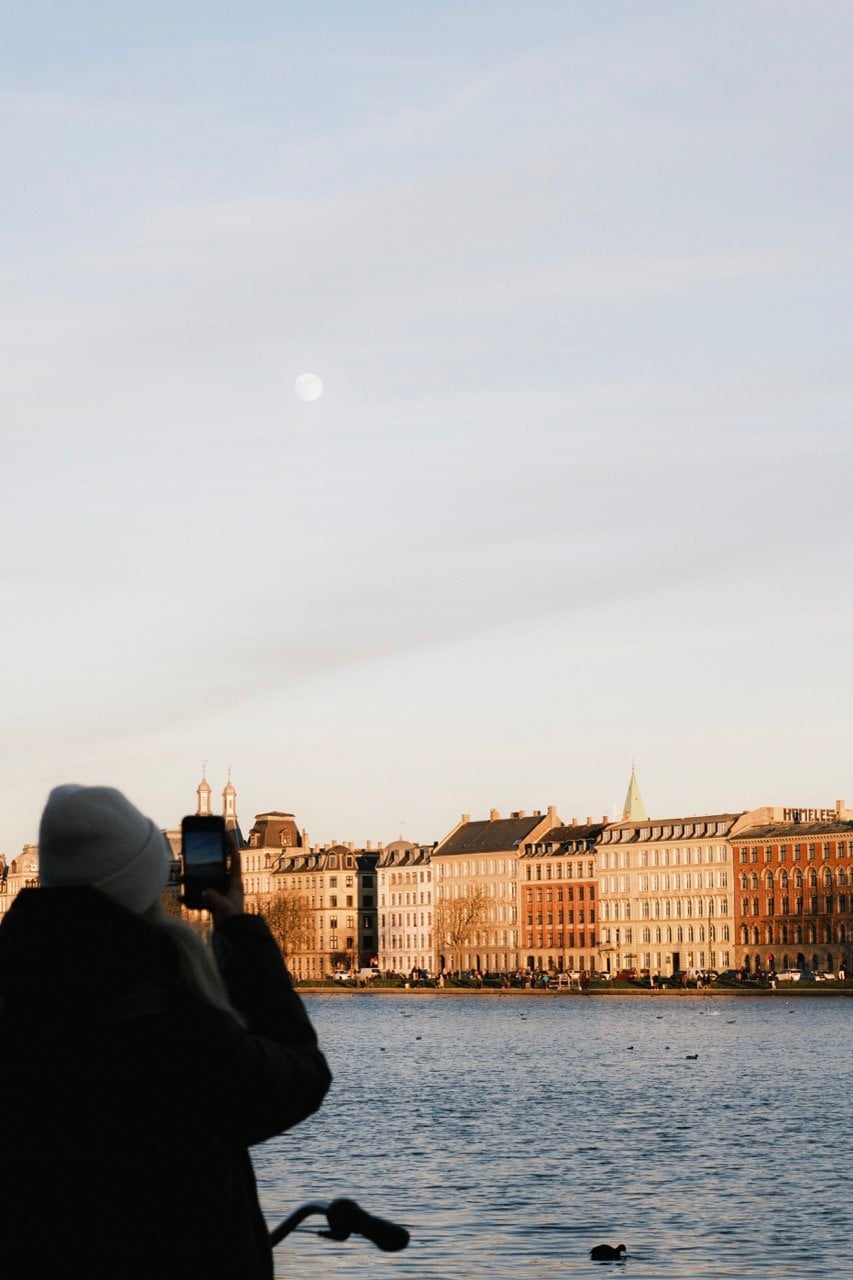 A woman photographing at The Lakes in Copenhagen