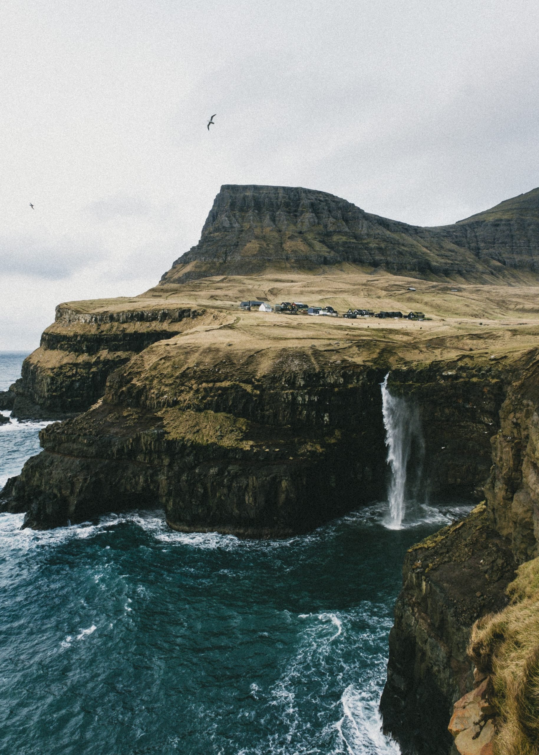 A photo of a mountain and a waterfall in the Faroe Islands