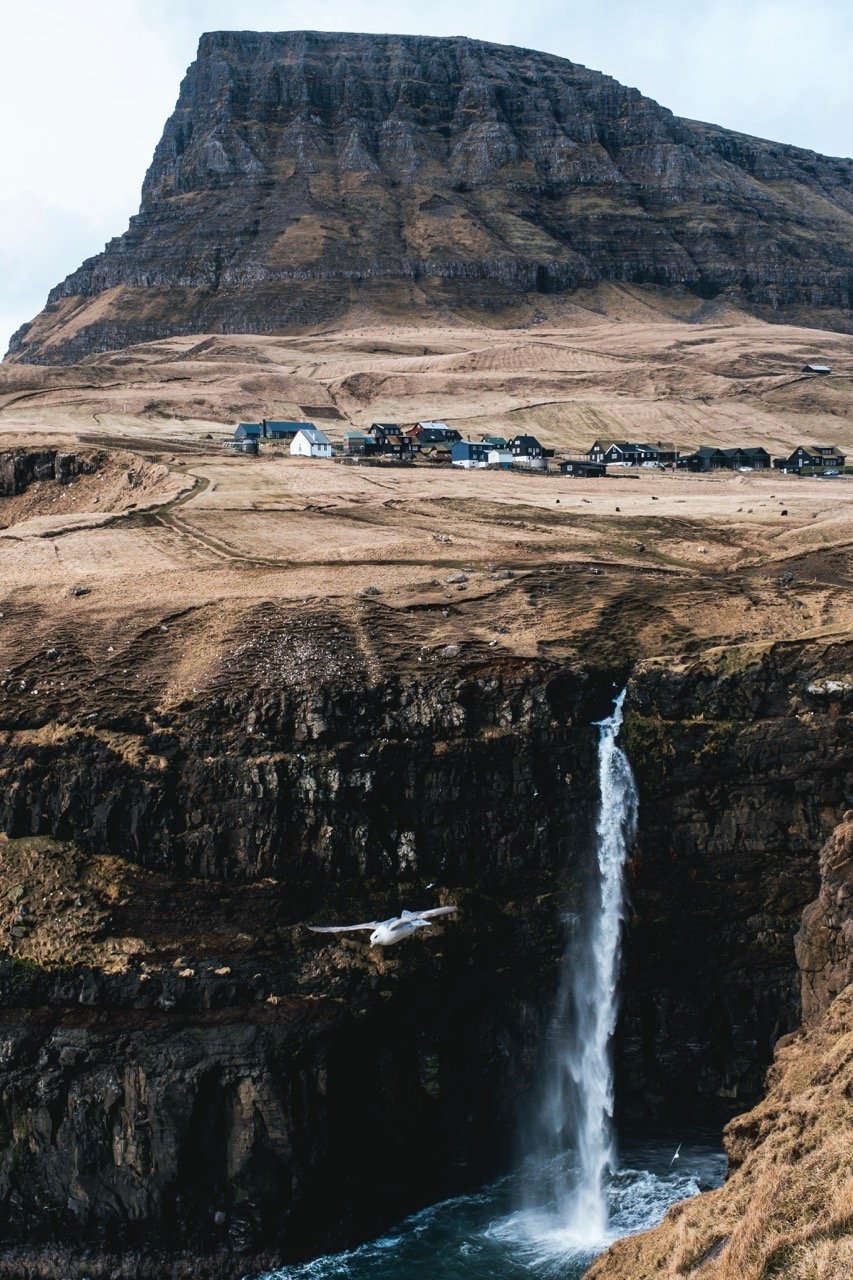 Photo of a village, mountain, and waterfall in the Faroe Islands