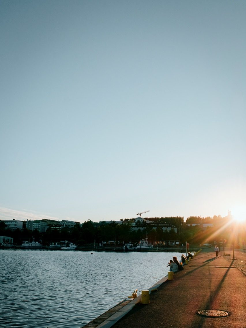 People sitting by the harbor in Jyväskylä, Finland