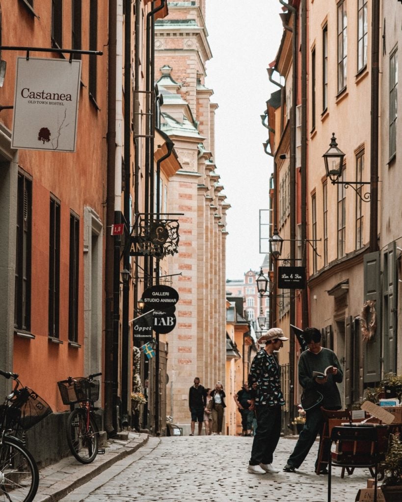 Two people reading a book outside a shop in Gamla Stan, Stockholm
