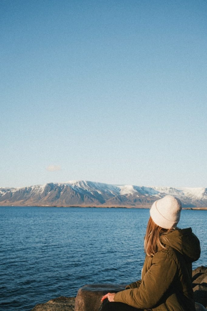 A woman looking toward Mount Esja from Sæbraut in Reykjavík, Iceland