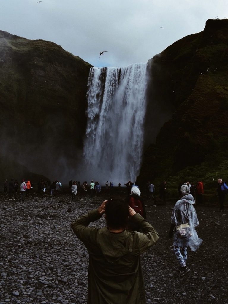 A person photographing waterfalls in Iceland