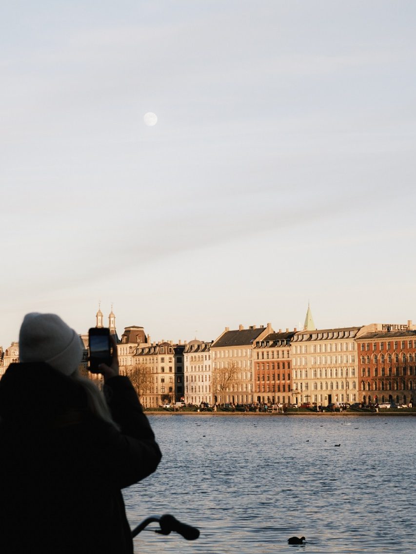 A woman photographing at The Lakes in Copenhagen