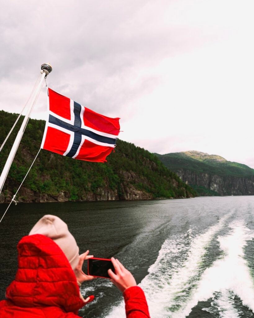 A tourist taking photos on a tour of the Osterfjord in Norway