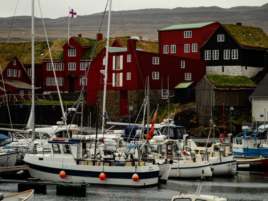 Boats in the harbor with the district of Tinganes behind it in Tórshavn, Faroe Islands