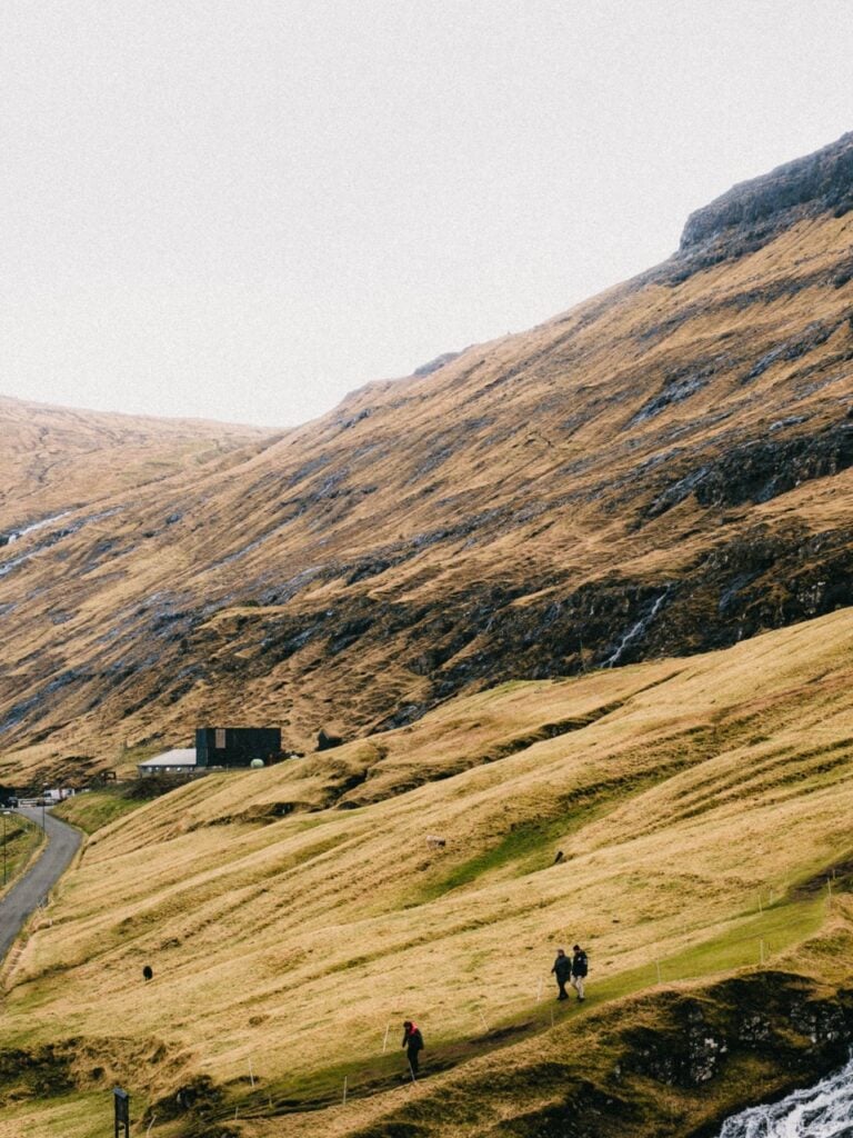 People hiking in Saksun, Faroe Islands