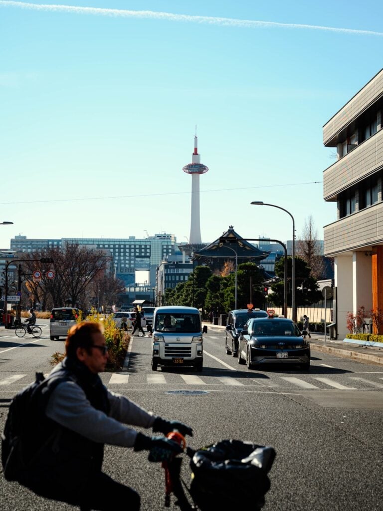 A man cycling on a street in Kyoto, Japan