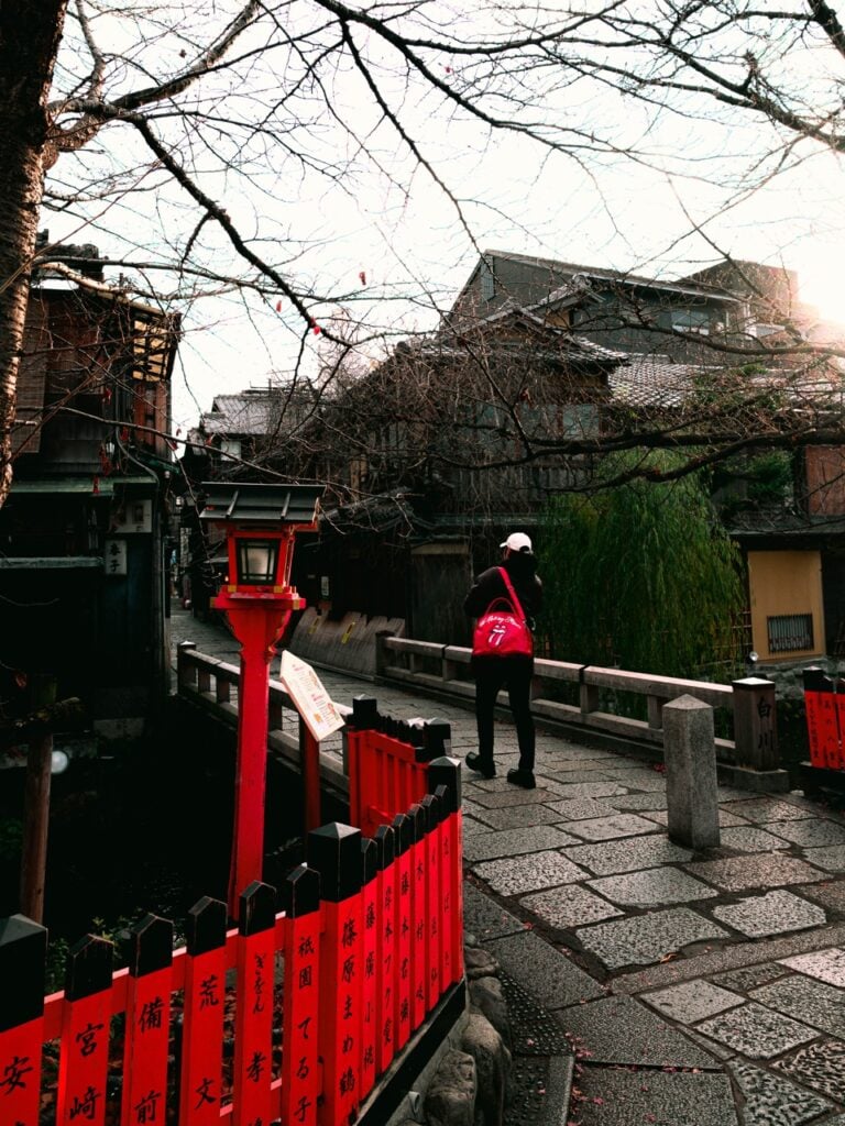 A person walking across a bridge in Kyoto, Japan