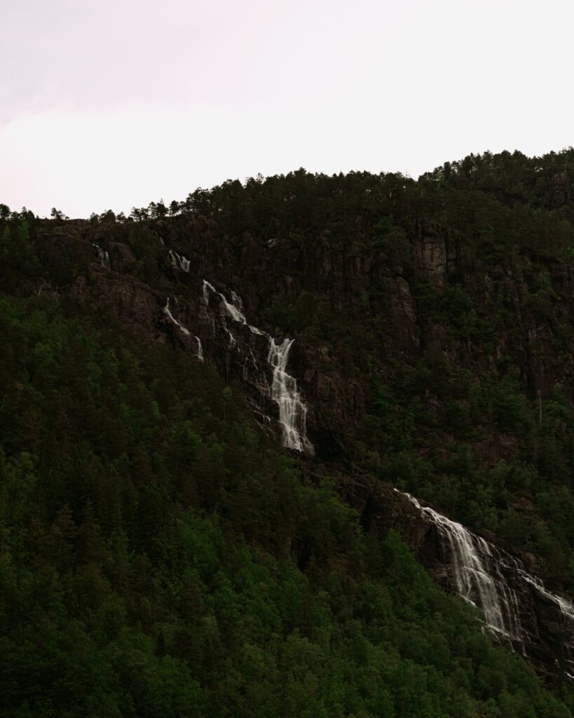 A waterfall next to a fjord in Norway
