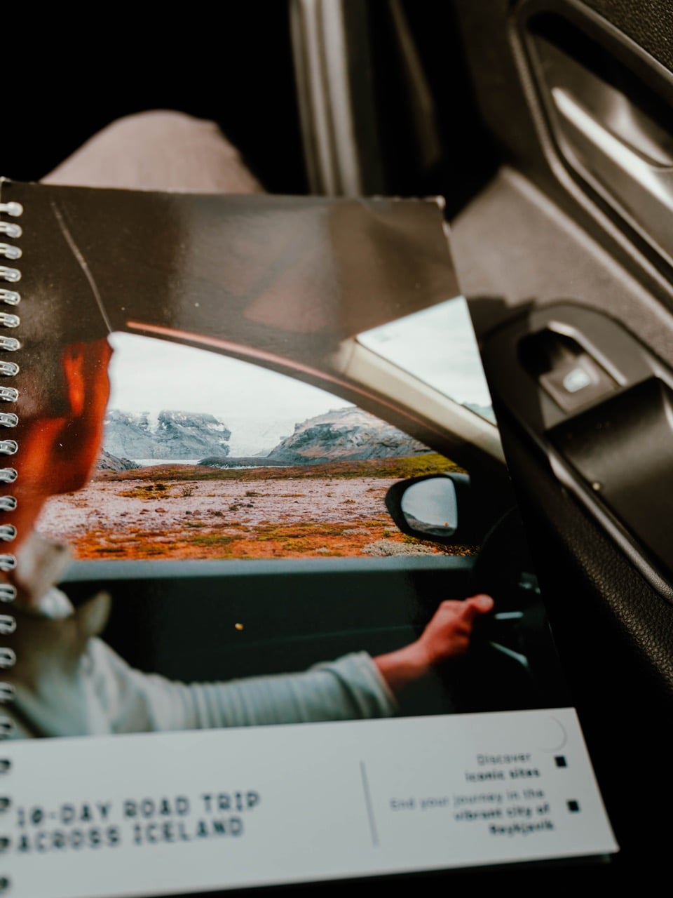Iceland Nomads Guidebook on a Person's Lap in a Car