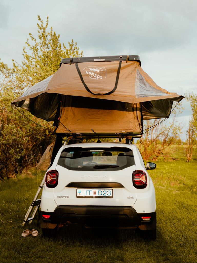 Setting up a rooftop tent at a campsite in Iceland