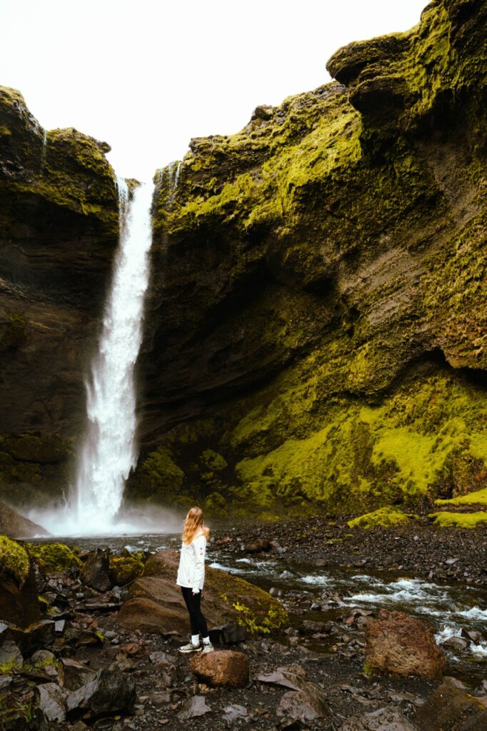A woman standing at the Kvernufoss waterfall in Iceland