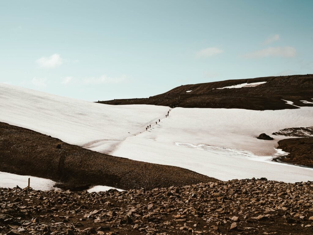 Hiking across a snow bridge on the Laugavegur Trail in Iceland