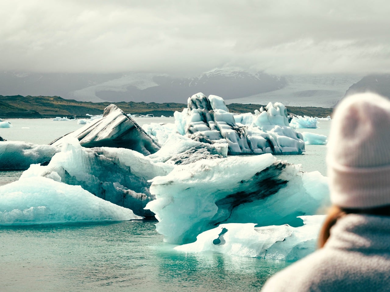 A person looking at icebergs at the Jökulsárlón glacier lagoon in Iceland